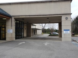 Image of Dr. Mark Brown's clinic exterior showing the building entrance with signage, clinic logo, and office hours displayed on the door.