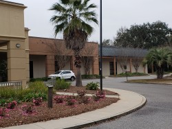 Image of Dr. Mark Brown's clinic exterior showing the building entrance with signage, clinic logo, and office hours displayed on the door.