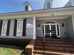 Image of Dr. Mark Brown's clinic exterior showing the building entrance with signage, clinic logo, and office hours displayed on the door.