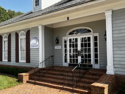 Image of Dr. Mark Brown's clinic exterior showing the building entrance with signage, clinic logo, and office hours displayed on the door.